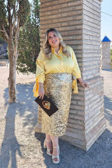 Chica rubia de talla grande con camisa amarilla con lazos de talla grande. Look de fiesta.