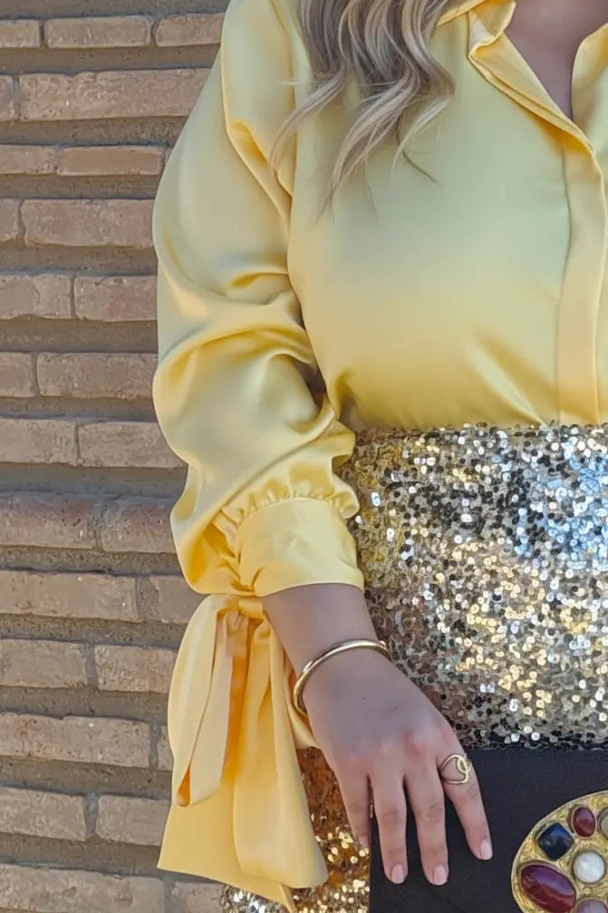 Detalles del puño con lazo de la camisa elegante de talla grande amarilla.