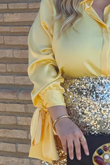Detalles del puño con lazo de la camisa elegante de talla grande amarilla.