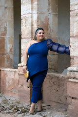 Bonito look de talla grande compuesto de un top asimétrico de crepe azul marino con manga abullonada de organza y pantalón de talla grande azul de corte recto tobilleros.