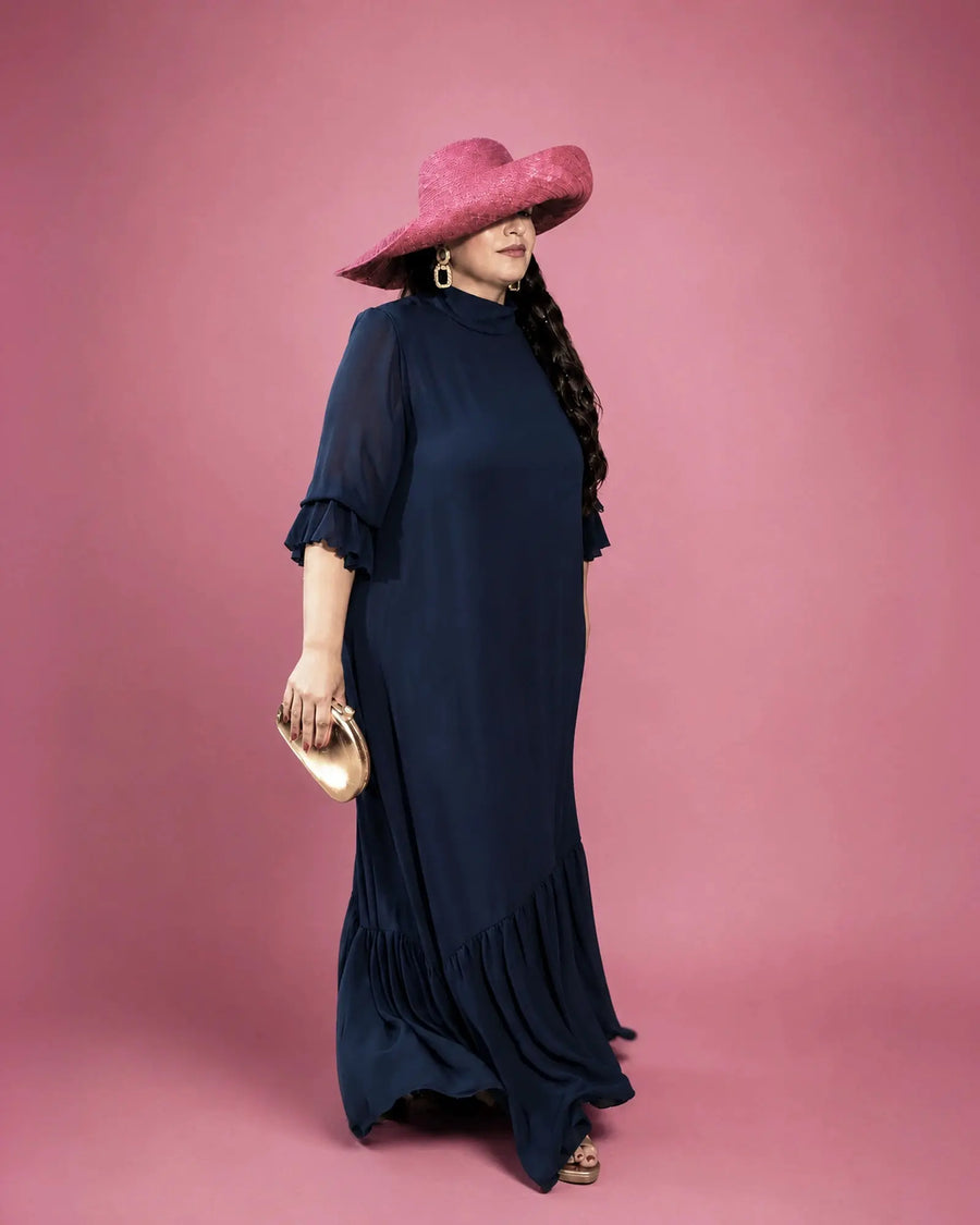 Vestido Marina de gasa azul marino con cuello alto y mangas de volante doble, look completo con pamela fucsia, talla grande