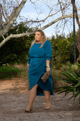 Vestido de talla grande color crepe azul petróleo con sobre falda tipo pareo anudada. Elegante y juvenil