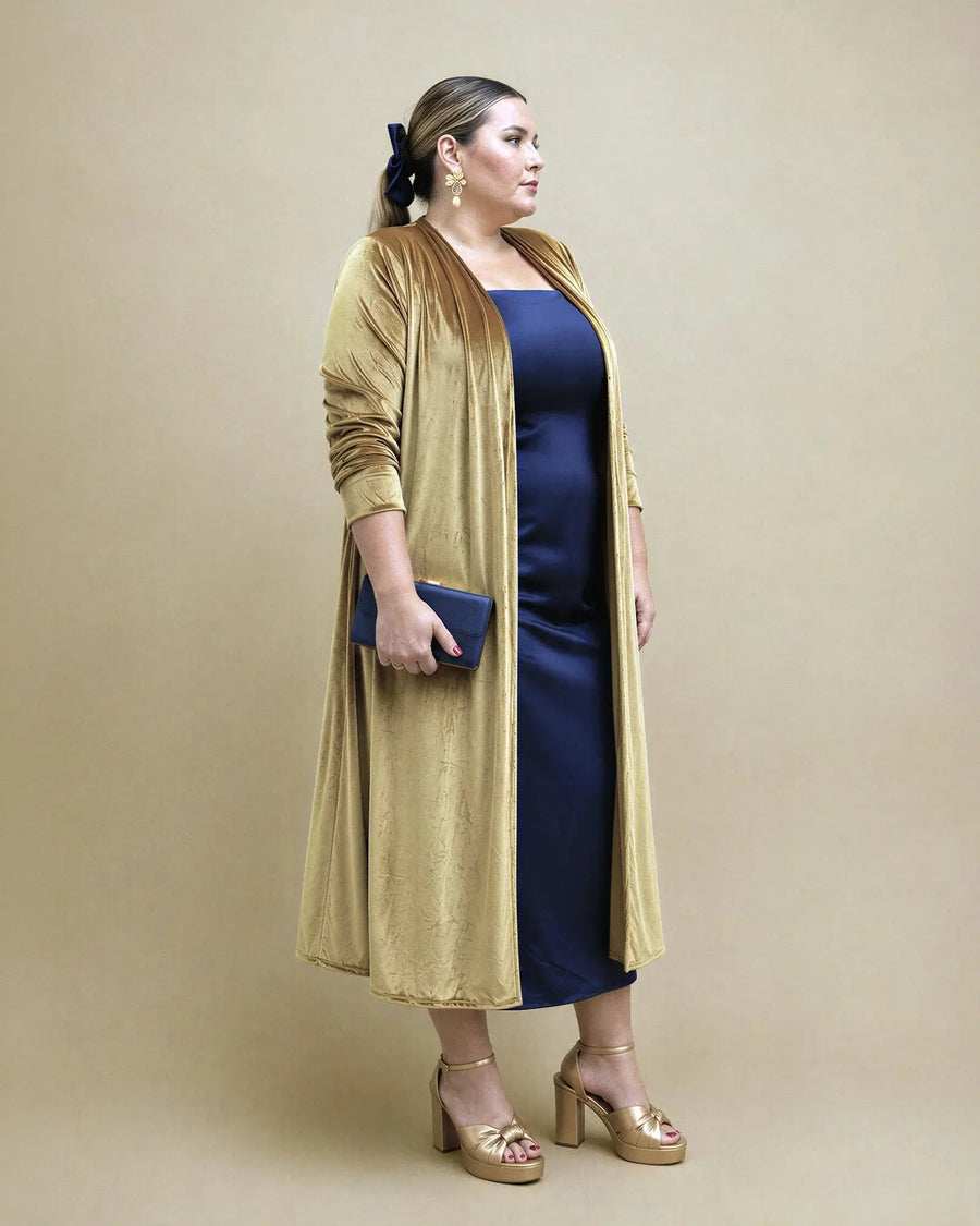 Chaqueta larga Candela de terciopelo color aceite sobre vestido azul marino, vista de perfil, talla grande