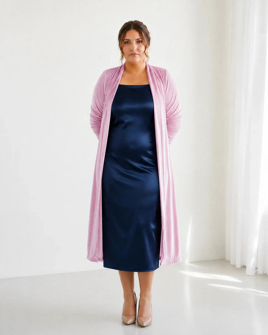 Chaqueta de terciopelo Candela en rosa palo, vista frontal de cuerpo entero sobre vestido mercedes azul marino, moda tallas grandes
