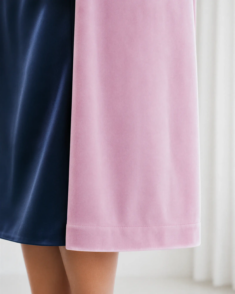 Detalle del bajo y la caída de la chaqueta de terciopelo Candela en rosa palo, combinada con vestido mercedes azul marino