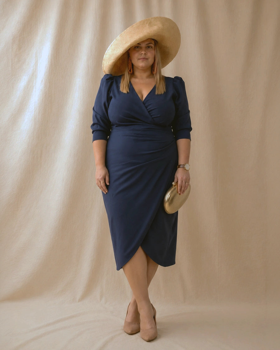 Vestido Fátima azul marino con abertura delantera tipo tulipán, pose con piernas cruzadas, talla grande