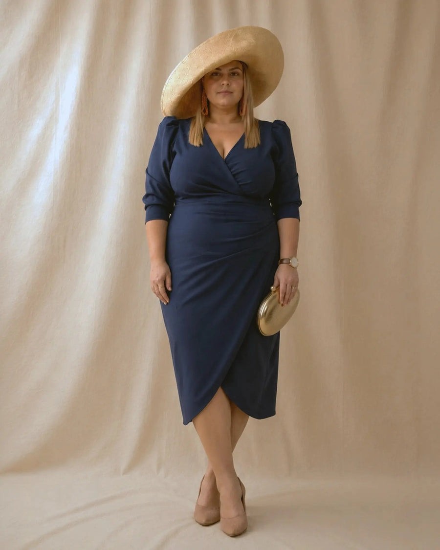 Vestido Fátima azul marino con abertura delantera tipo tulipán, pose con piernas cruzadas, talla grande