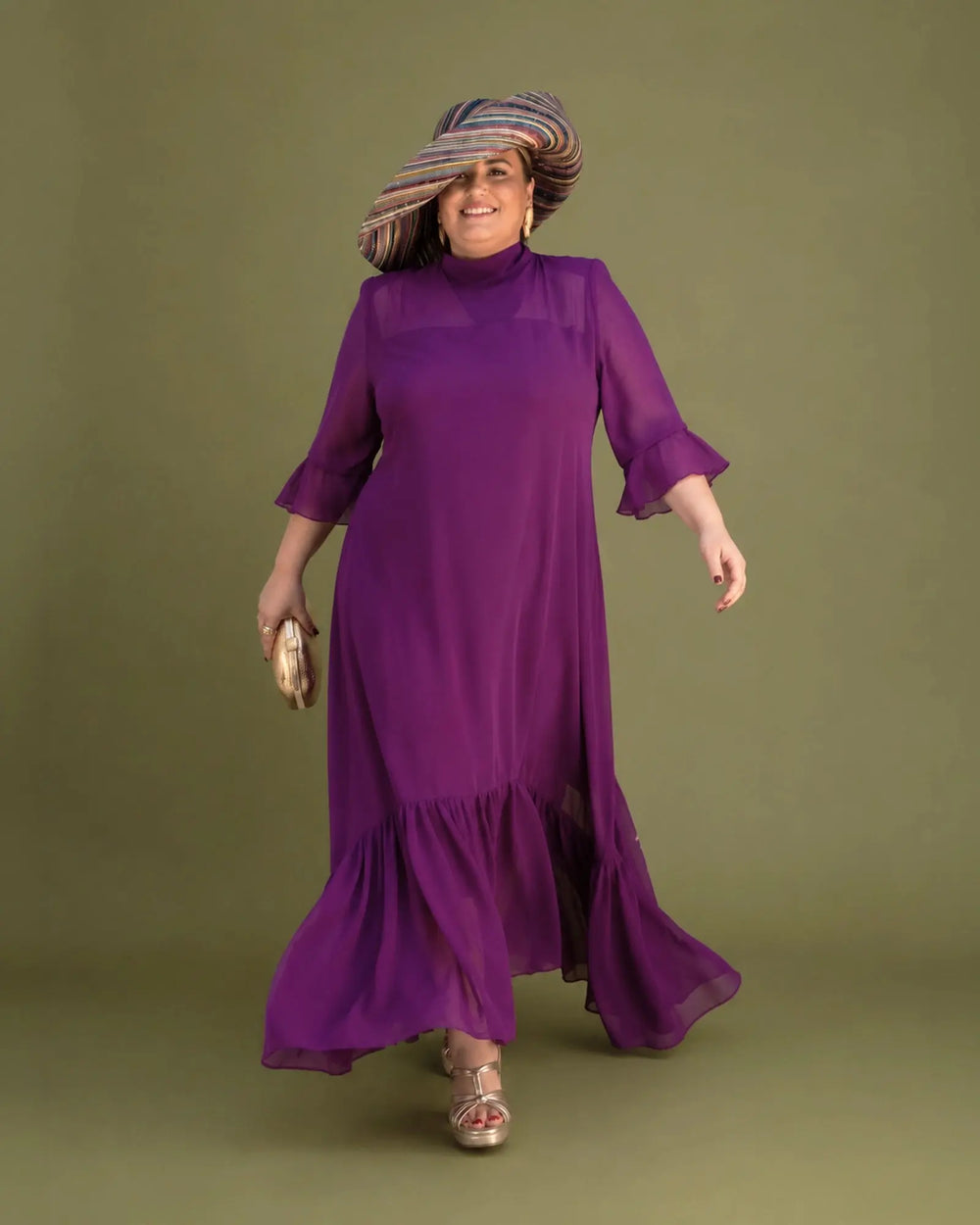 Vestido Marina de gasa color buganvilla con vuelo en la falda, modelo caminando, talla grande