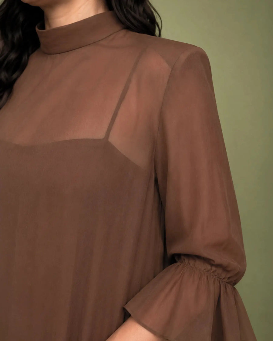 Detalle del cuello alto y la transparencia de gasa en el hombro del vestido Marina marrón
