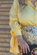 Detalles del puño con lazo de la camisa elegante de talla grande amarilla.