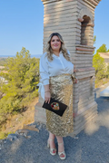 Camisa blanca de vestir de talla grande con lazos en la manga. Conjunto con falda de talla grande con lentejuela dorada.
