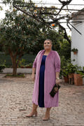 sofisticado abrigo de terciopelo rosa, de longitud midi y mangas largas. Ideal para ocasiones especiales, combina estilo y elegancia impecablemente.