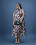 Vestido Adela midi estampado combinado con clutch verde, vista de tres cuartos, talla grande