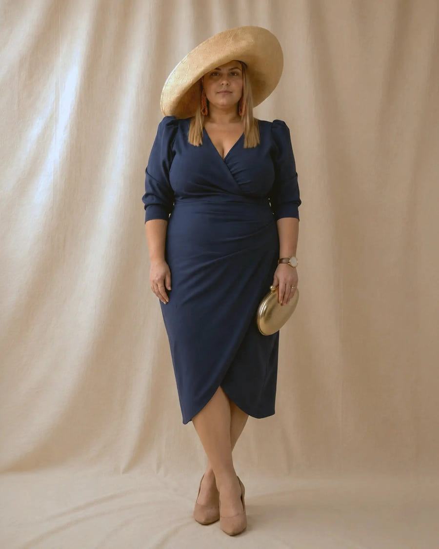 Vestido Fátima azul marino con abertura delantera tipo tulipán, pose con piernas cruzadas, talla grande