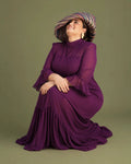 Vestido Marina de gasa color buganvilla con cuello alto y mangas de campana, modelo sentada sonriendo, talla grande